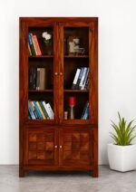 Sheesham wood bookshelf with glass doors and diamond-carved lower storage doors in teak finish, front view