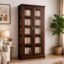 Dark walnut finish sheesham wood glass door bookcase with brass ring handles styled in a living room with books